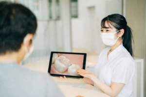 資料を用いて患者様に治療の説明をしている歯科スタッフの写真